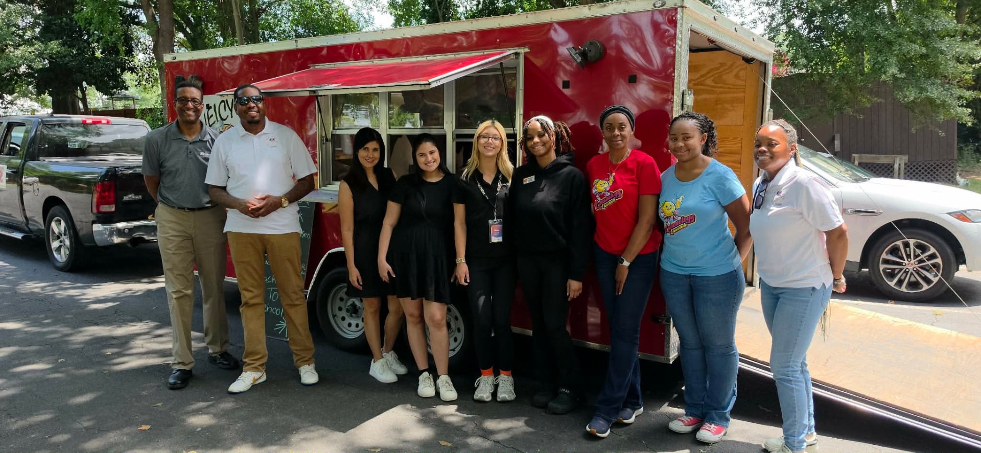Community partners gathered in front of a red food truck