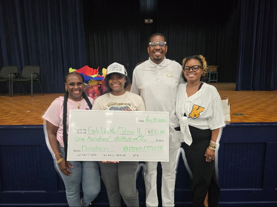 Girls Like Me representatives and supporters presenting a $100 check
