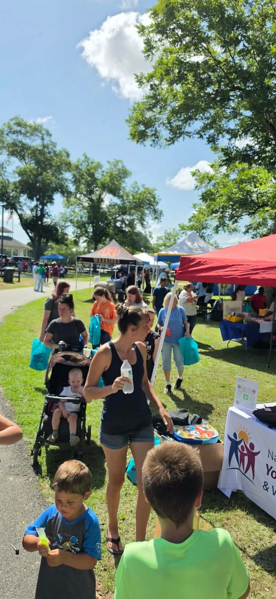 Families visiting the Alliance table at an outdoor community event